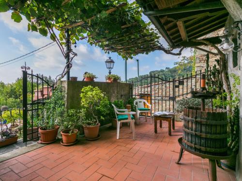 a patio with chairs and tables and a fence at Apartment La casa del Fale di Collodi by Interhome in Collodi