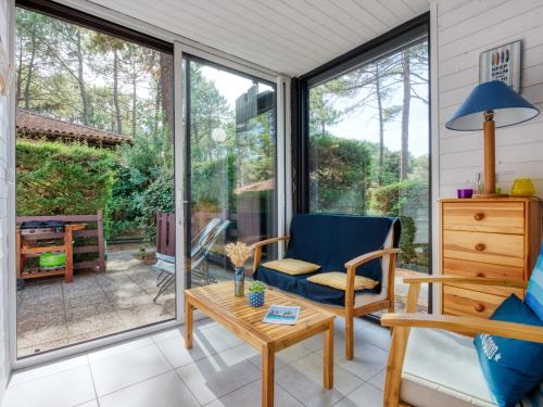 une véranda avec une chaise et une table dans l'établissement Holiday Home Les Pins-13 by Interhome, à Lacanau