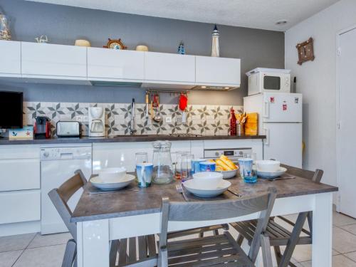 - une cuisine avec une table avec des bols et des assiettes dans l'établissement Holiday Home Les Pins-13 by Interhome, à Lacanau