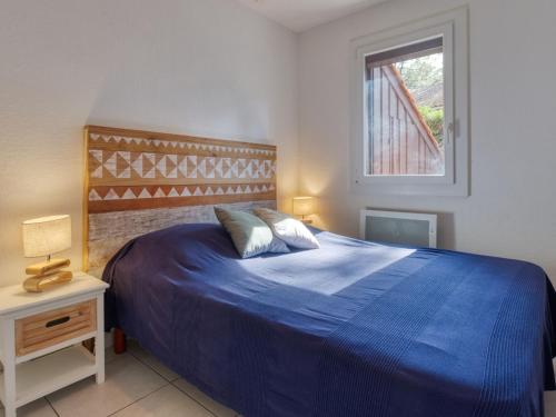 une chambre avec un lit bleu et une fenêtre dans l'établissement Holiday Home Les Pins-13 by Interhome, à Lacanau