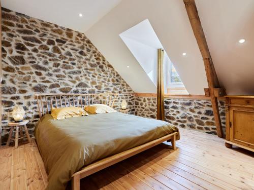 une chambre avec un mur en pierre et un lit dans l'établissement Holiday Home la favrais by Interhome, à Saint-Aubin-de-Terregatte