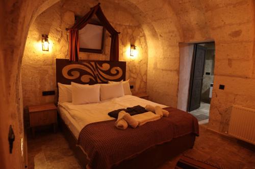 a bedroom with a bed in a stone room at Stone Owl Otel & Restaurant in Uchisar