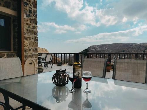 a table with two glasses of wine on a balcony at VILLA CASTELLOS 