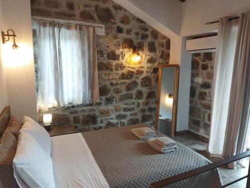 um quarto com uma cama grande e uma parede de pedra em VILLA CASTELLOS 