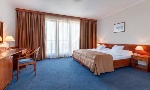 a hotel room with a large bed and a desk at April hotel Panorama in Rychnov nad Kněžnou