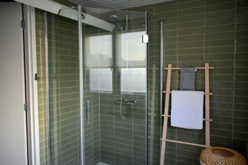 baño con ducha de azulejos verdes en Zeewind en Zonneschijn, en Oostburg