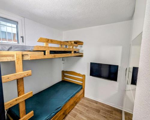 1 Schlafzimmer mit 2 Etagenbetten und einem Flachbild-TV in der Unterkunft Ecrin Alpe d'huez in Huez