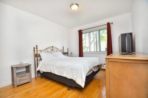 - une chambre avec un lit et une télévision dans l'établissement Coquette 3.5 pour 4 personnes, à Montréal