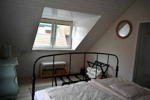 een slaapkamer met een bed en een raam op zolder bij Zeewind en Zonneschijn in Oostburg