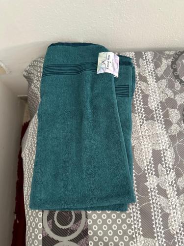 ein grünes Handtuch auf dem Bett in der Unterkunft oNLY MALE GENDER ROYAL LUXURY PARTITION SMALL ROOM in Abu Dhabi