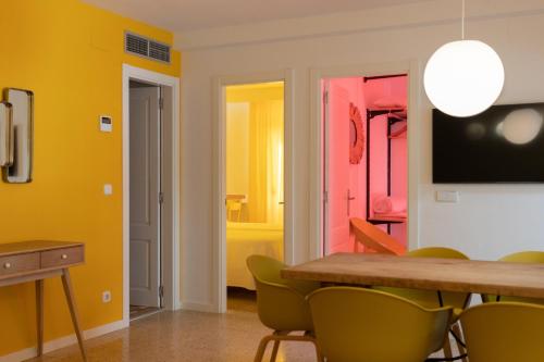 a dining room with a table and green chairs at Apartamentos Boutique Poniente Playa in San Antonio