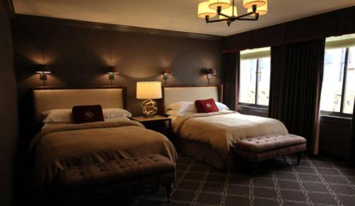 a bedroom with two beds and a chandelier at Los Angeles Athletic Club in Los Angeles