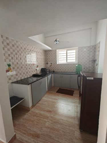 an empty kitchen with a sink and a refrigerator at Downtown Service Apartments in Mysore
