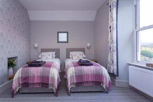 a bedroom with two beds and a window at Howgills House Hotel in Sedbergh