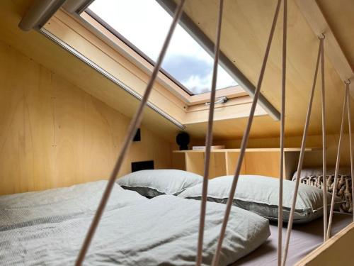 a loft bed with a window in a bedroom at Tiny House zwischen Berlin und Potsdam in Berlin