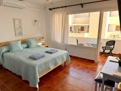 a bedroom with a bed and a large window at APT Borras & Roca Plana, fronte mare in Es Pujols
