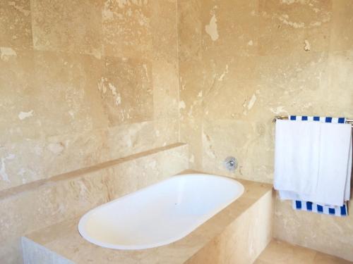 W łazience znajduje się wanna i ręcznik. w obiekcie Mountain and Harbour Views - Grand Vue Cottage w Kapsztadzie
