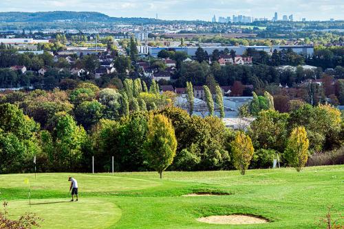 un homme joue au golf sur un parcours dans l'établissement Le Green des Impressionnistes, à Ennery