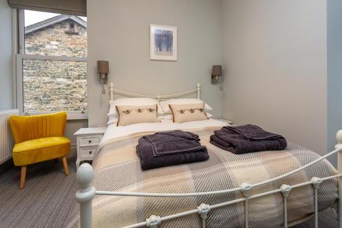 1 dormitorio con 1 cama y 1 silla amarilla en Howgills House Hotel en Sedbergh