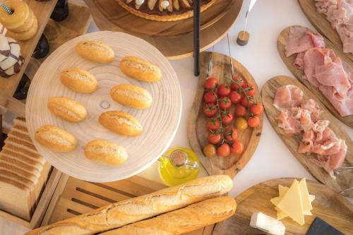 a table topped with plates of bread and other foods at Apartamentos Boutique Poniente Playa in San Antonio