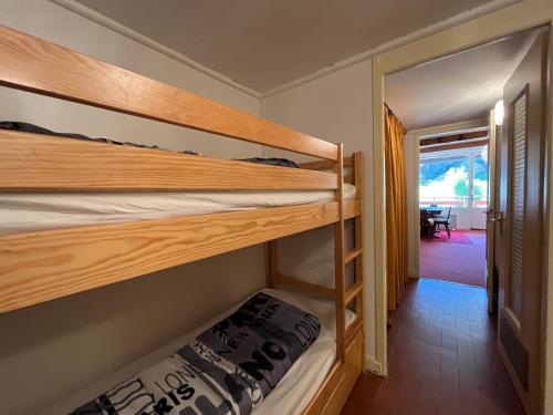 Cette chambre comprend 2 lits superposés et une porte. dans l'établissement Appartement T2 plein sud au pied des pistes, 6 pers, Box à skis - FR-1-165A-26, à Enchastrayes