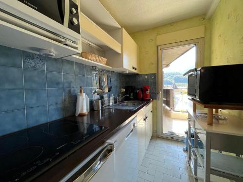 une cuisine avec un évier et un plan de travail dans l'établissement T2 Duplex à Barcelonnette avec Parc Privatif Arboré en Centre-Ville - FR-1-165A-38, à Barcelonnette