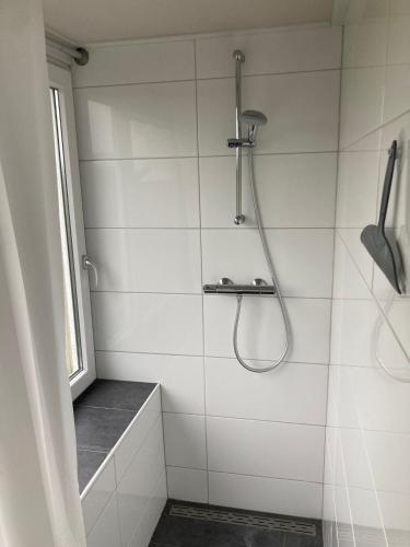 a white bathroom with a shower and a window at Vakantiewoning Seehouse in Oostkapelle