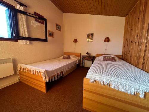 1 dormitorio con 2 camas y ventana en Appartement Enchastrayes, 2 pièces, 6 personnes - FR-1-165A-132 en Enchastrayes