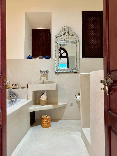 a bathroom with a sink and a mirror at Riad Tizwa Marrakech in Marrakech