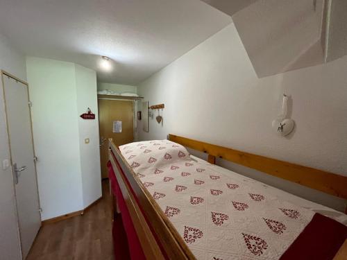 a bedroom with a bed with a red and white blanket at Appartement Enchastrayes, 2 pièces, 4 personnes - FR-1-165A-138 in Enchastrayes