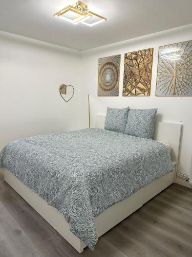 um quarto branco com uma cama com almofadas azuis em Stylish Apartment Disneyland Paris em Chessy