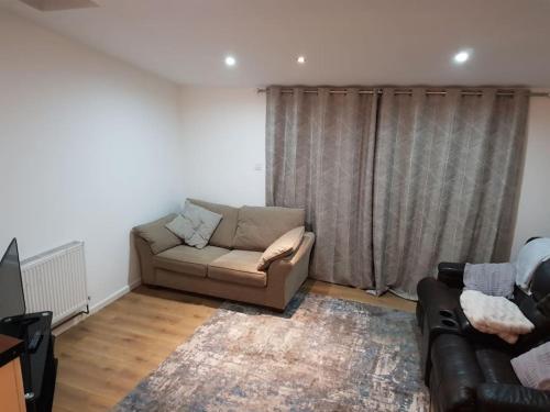 a living room with a couch and a table and a television at Spacious self-contained annexe in Horbury in Horbury