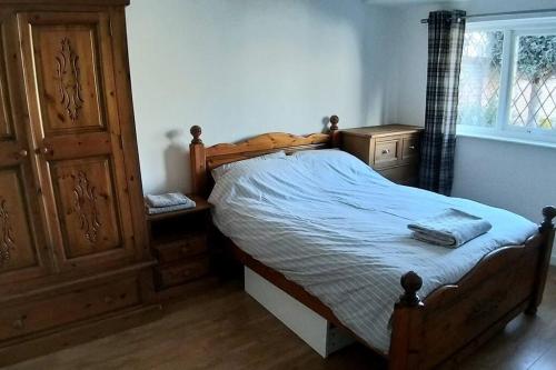 a bedroom with a wooden bed and a wooden dresser at Spacious self-contained annexe in Horbury in Horbury