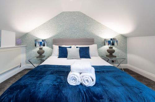 a bedroom with a blue bed with two towels at The Old Naval Laundry - Pure B in Plymouth
