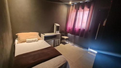 Habitación pequeña con cama y ventana en Pousada D’San Shower & Bed, en Vinhedo