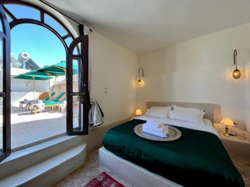 a bedroom with a bed with a view of a patio at Riad Tizwa Marrakech in Marrakech