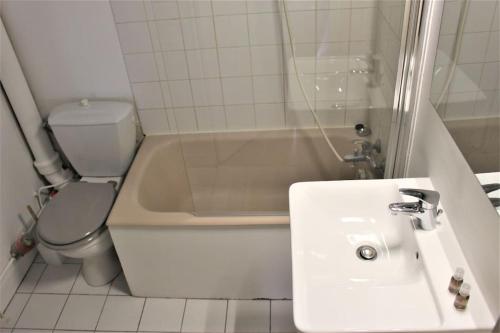 a white bathroom with a sink and a toilet at Charmant studio en centre-ville / proche gare in Le Havre