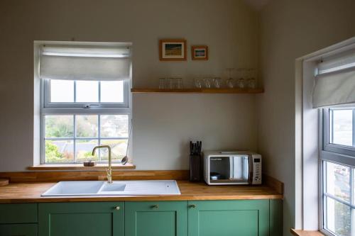 a kitchen with a sink and a microwave at The Malt House Artists' Residence in Newlyn