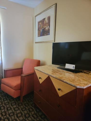 a room with a desk and a chair and a television at M Star Hotel Mansfield in Mansfield