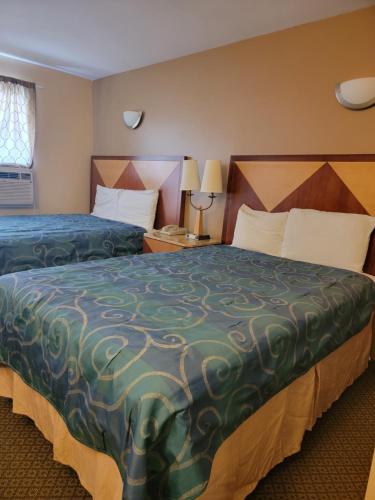 a hotel room with two beds and two lamps at M Star Hotel Mansfield in Mansfield