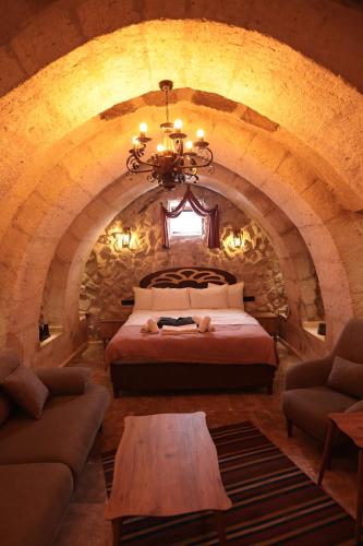 a bedroom with a bed in a stone wall at Stone Owl Otel & Restaurant in Uchisar