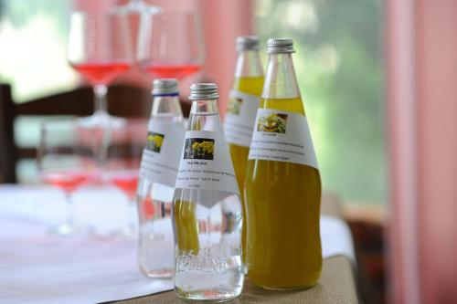 three bottles of wine sitting on a table with wine glasses at "Frogs House" Hotel & Restorant Slow Food in Lushnjë