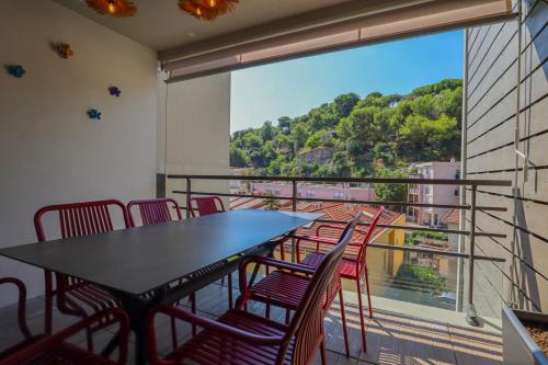 a dining room with a table and chairs and a large window at "L'Idyllique" Parking, Piscine, Plage, Calme assuré, Gare in Roquebrune-Cap-Martin