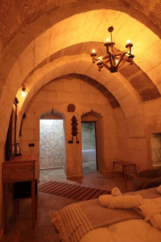 a large room with a stone wall and a chandelier at Stone Owl Otel & Restaurant in Uchisar
