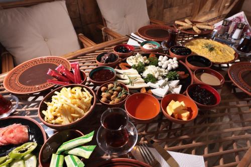 a table with many bowls of food on it at Stone Owl Otel & Restaurant in Uchisar