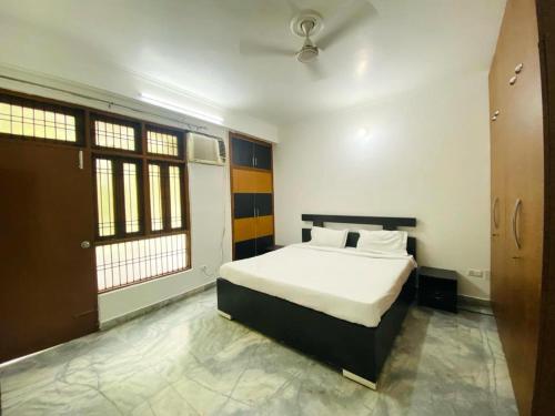 1 dormitorio con 1 cama en una habitación con ventanas en The white yard stays en Varanasi