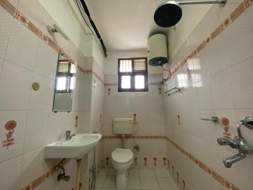 La salle de bains est pourvue de toilettes et d'un lavabo. dans l'établissement The white yard stays, à Varanasi