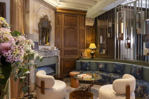 a living room with a couch and chairs and a fireplace at Hotel L de Lutece - Notre-Dame in Paris