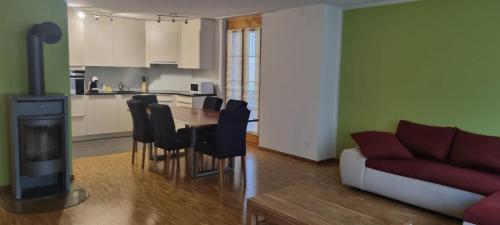 a kitchen and a living room with a table and a couch at Apartment Sofia in Wilderswil