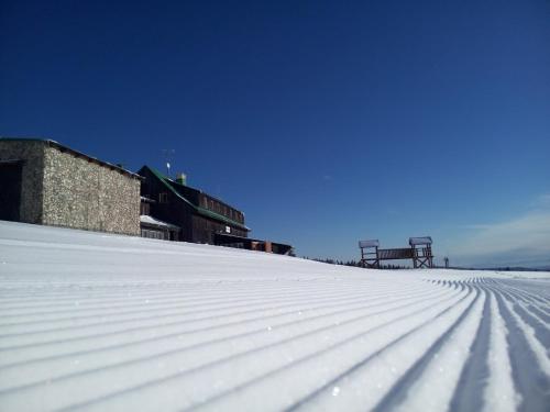 ペツ・ポト・スニェシュコウにあるLyžařská boudaの背景の雪屋根